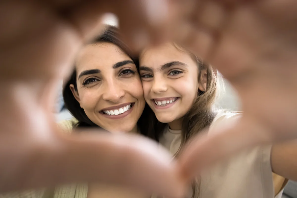 Mother and child making a heart shape with hands